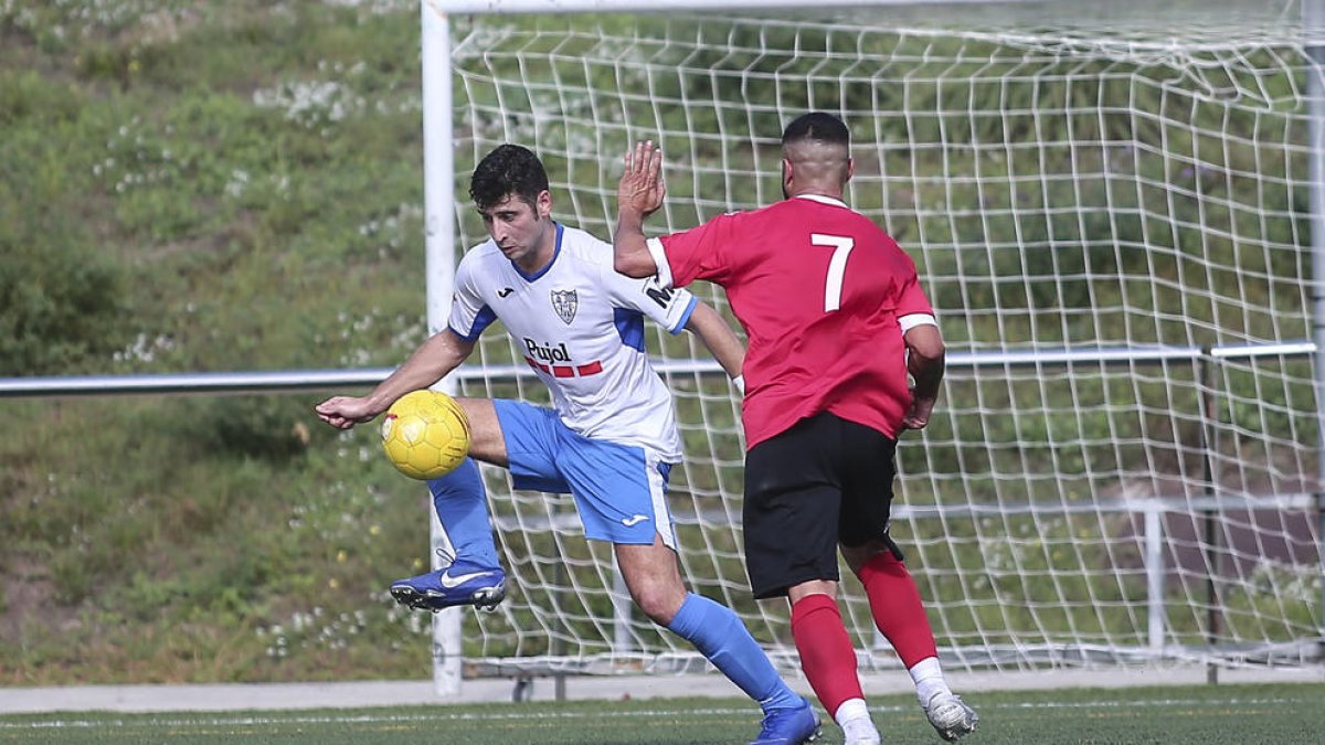 Un jugador del Mollerussa controla el esférico ante la presión de un jugador del Santboià.