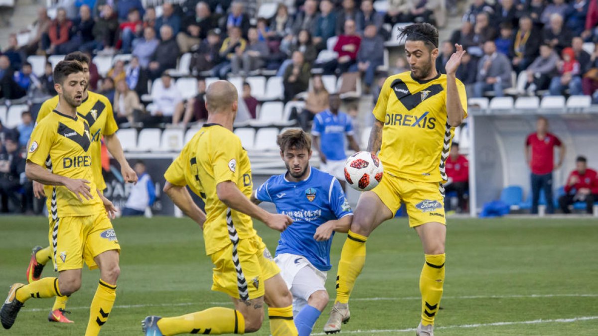 Fernando Cano es frenado por un defensa del Badalona dentro del área, en una acción atacante del Lleida.