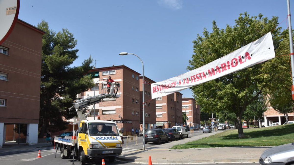 Un operario instala la pancarta de las fiestas de la Mariola.
