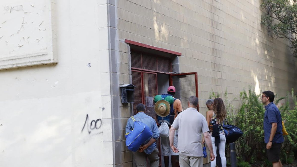 Un grupo de temporeros entra en L’Antorxa para utilizar el servicio de duchas y consigna a los pocos minutos de que el pabellón abriera.