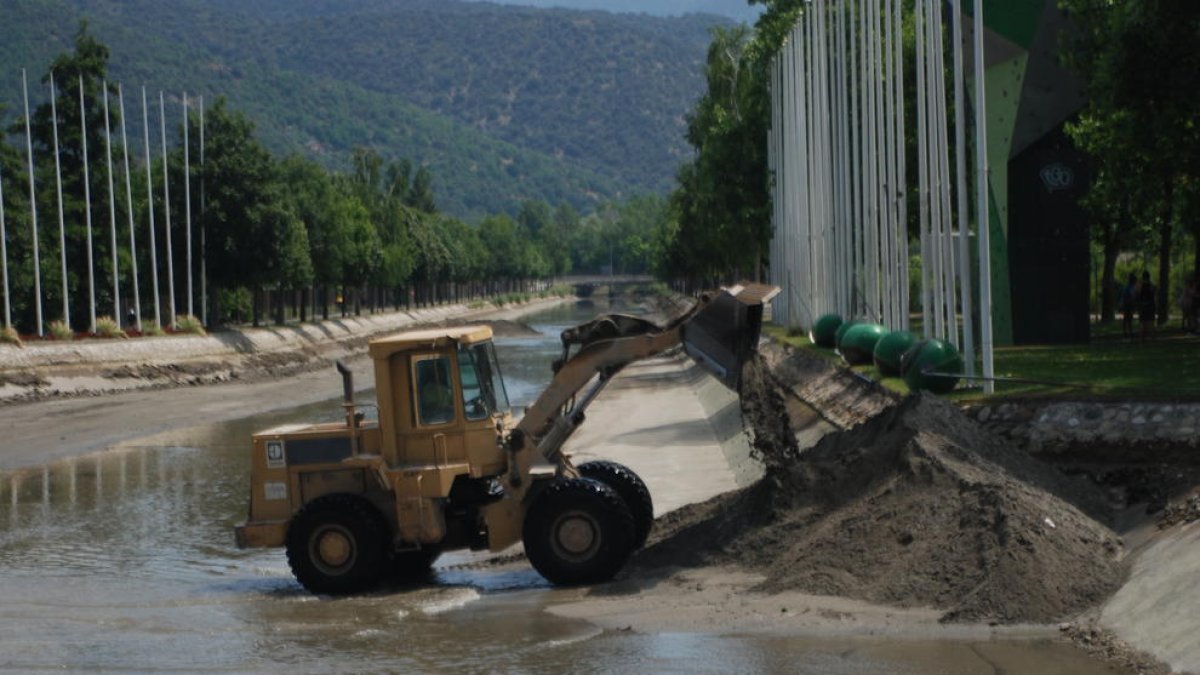 Una máquina excavadora retira el lodo acumulado en el canal de aguas tranquilas.