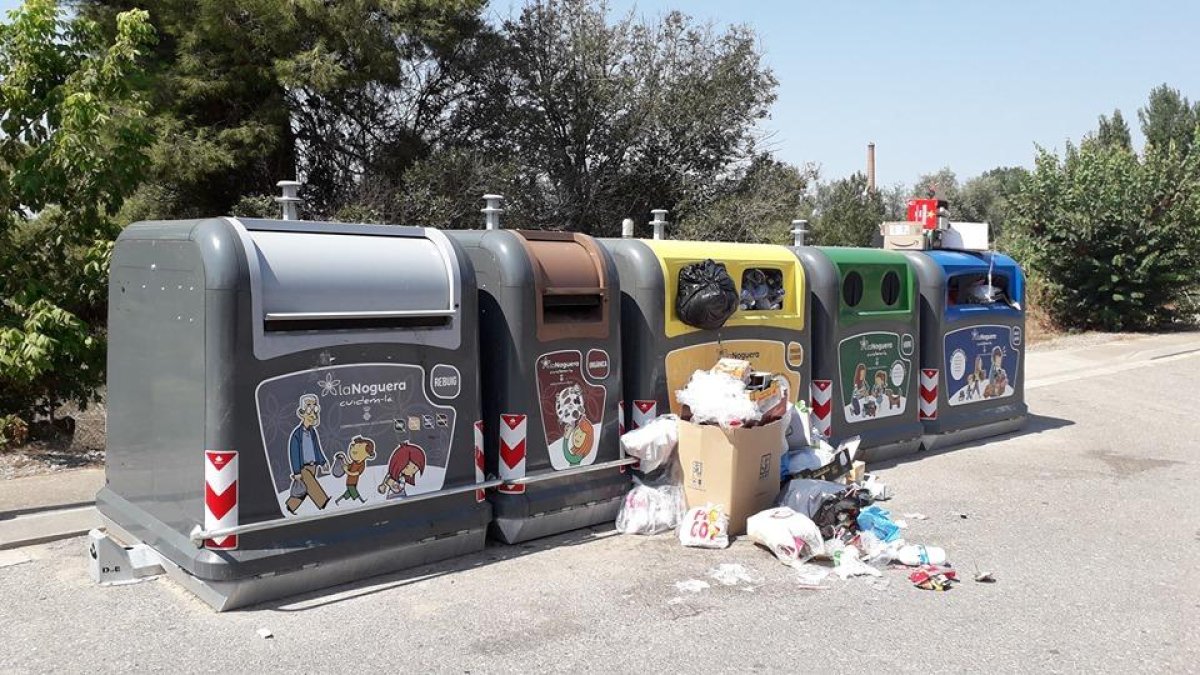 Imatge d’una de les illes de contenidors de Térmens amb bosses d’escombraries tirades al carrer.