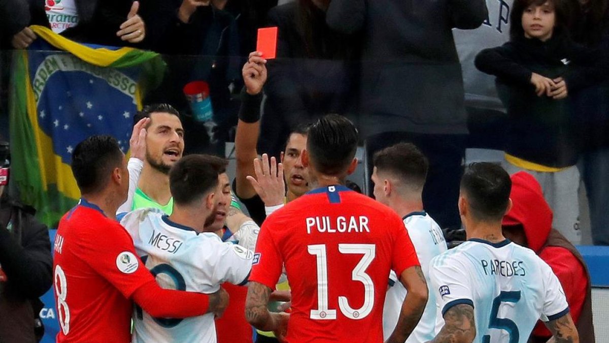 El árbitro expulsa a Messi y a Medel, ayer durante el partido.