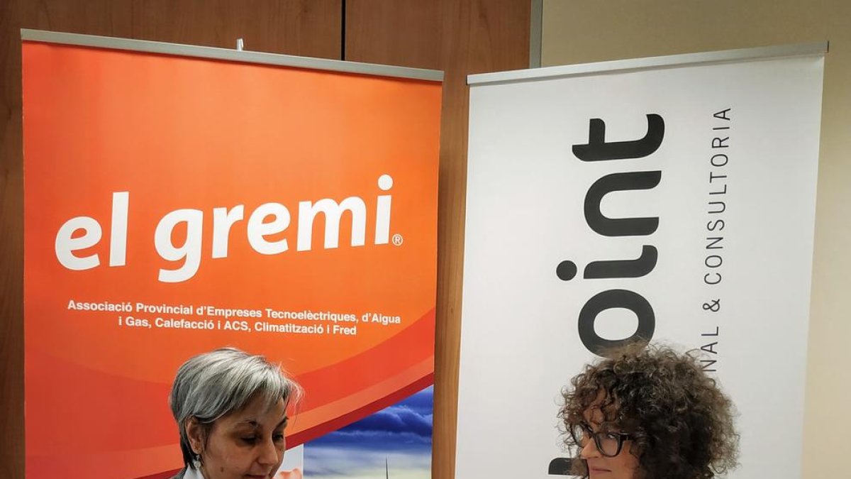 Les responsables del gremi i Helpoint, al firmar el conveni.