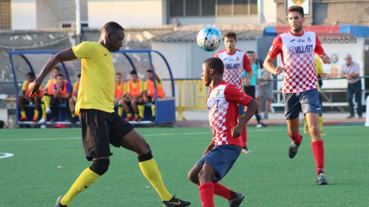 Buba Mballo, jugador del Balaguer, intenta controlar el balón ante la potencia física de Cheikh Saad, del EFAC Almacelles.