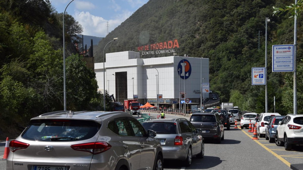 Retencions, pas alternatiu de camions i desviació de cotxes al matí a Andorra (esquerra) mentre s’iniciaven els treballs per assegurar el pendent (dreta).