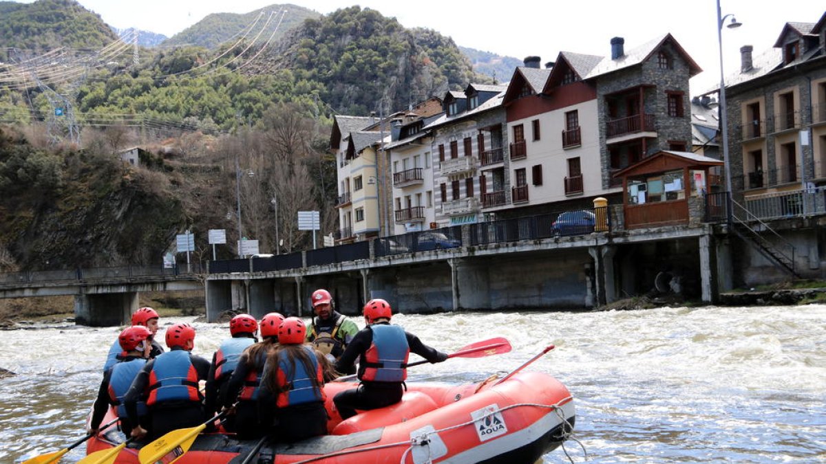 Una barca de rafting, con Llavorsí en el fondo.