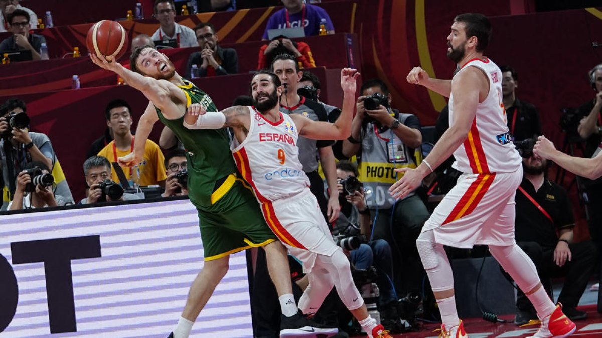 Ricky Rubio i Marc Gasol intenten prendre la pilota a l’australià Nic Kay.