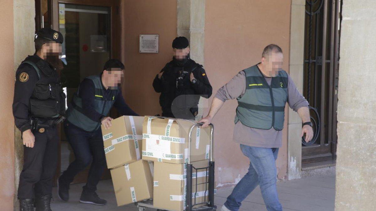 Agentes de la Guardia Civil se llevan del ayuntamiento de Almacelles cajas con documentos.