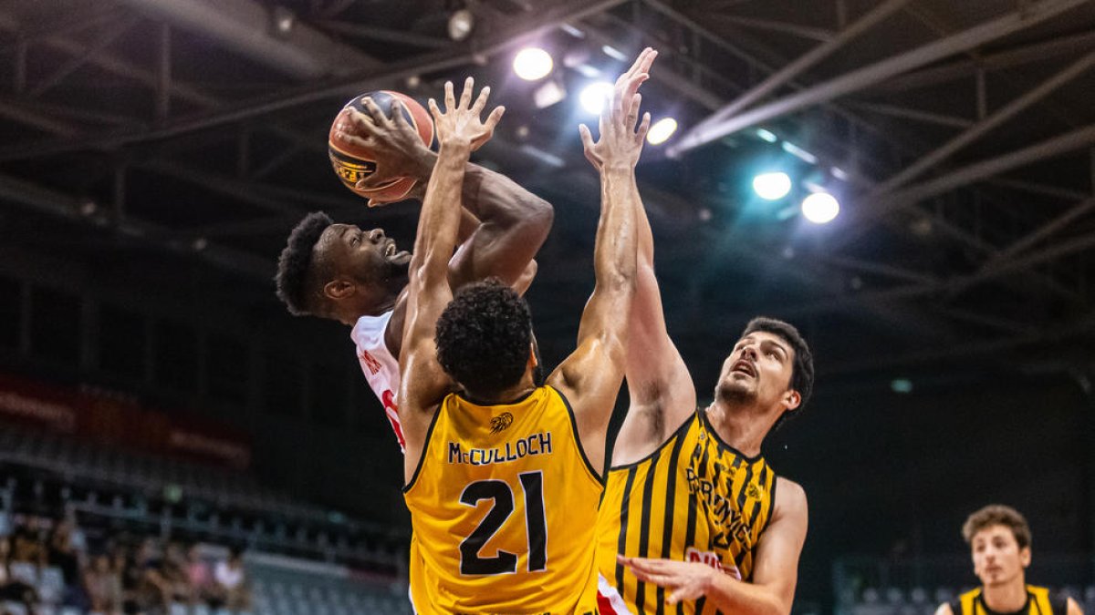 Carlos Gasque y David McCulloch intentan evitar el lanzamiento de Antonio Hester.