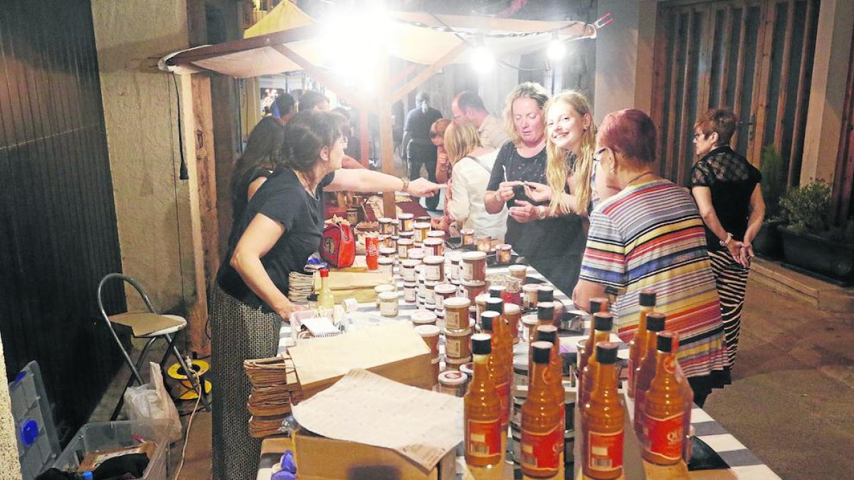 Un grupo comprando en una de las paradas de la feria nocturna de Camarasa.