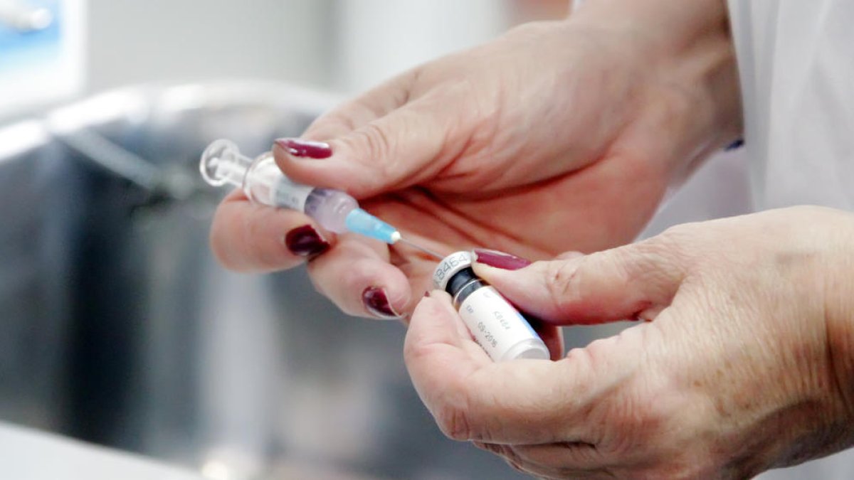 Una infermera prepara una vacuna.