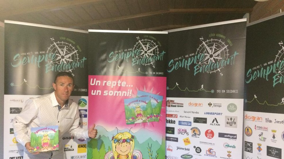 El atleta de Tàrrega Raül Arenas, posando con el libro de cuentos infantiles de Noe Gaya.