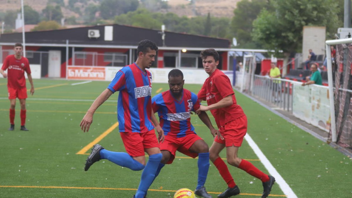 Dos jugadors del Vilanova de la Barca protegeixen l’esfèric davant la pressió d’un jugador de l’Alpicat B.