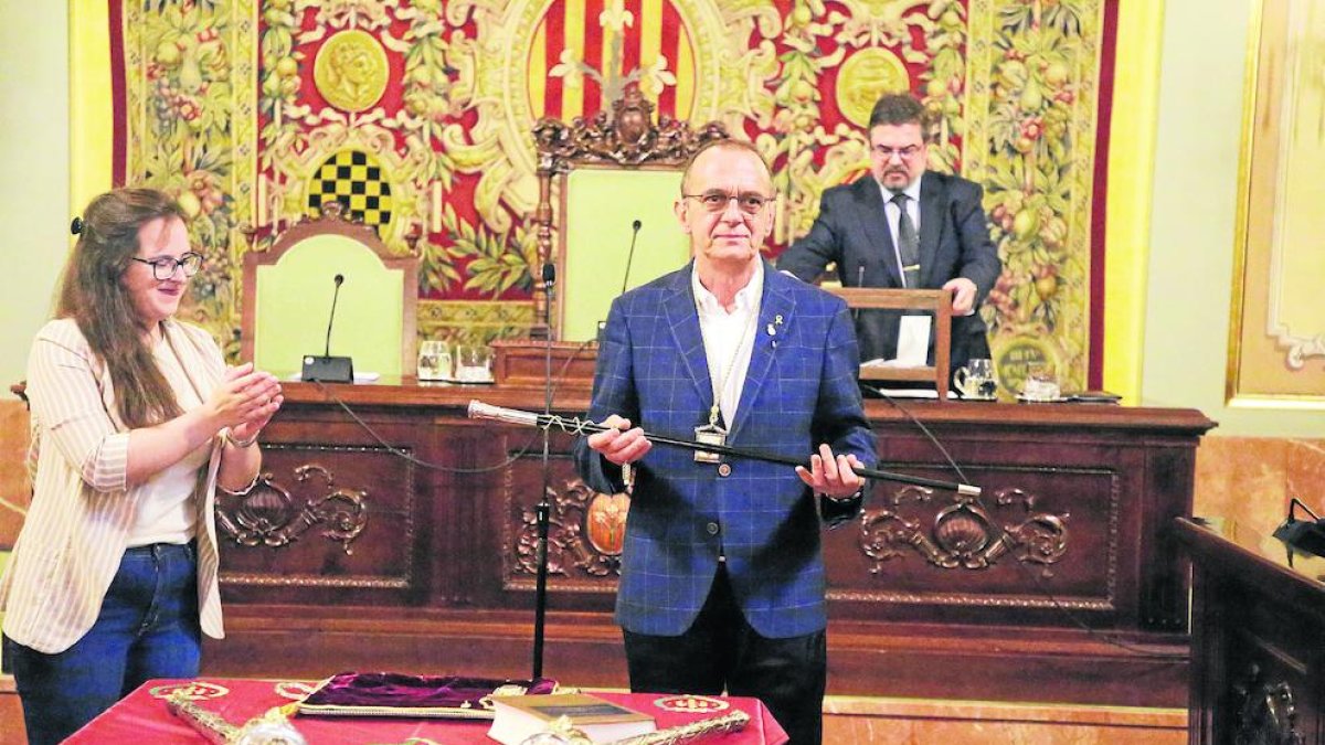 Miquel Pueyo muestra la vara de alcalde, que le entregó la edil del Comú Elena Ferré, la más joven del pleno.