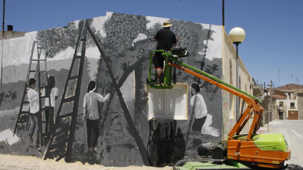 Treballs per pintar un gran mural commemoratiu a Maials.
