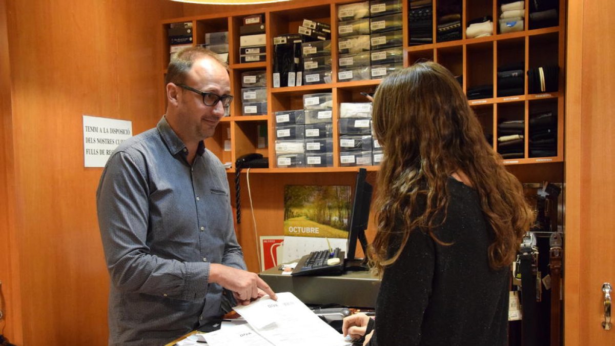 Toni Escribà mostrando a una clienta cómo sellar el ‘tax free’ en la máquina de La Farga de Moles.