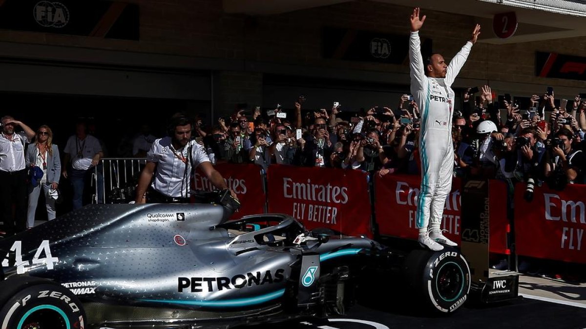 Lewis Hamilton celebra su sexto Mundial de Fórmula Uno subido en una rueda de su monoplaza.