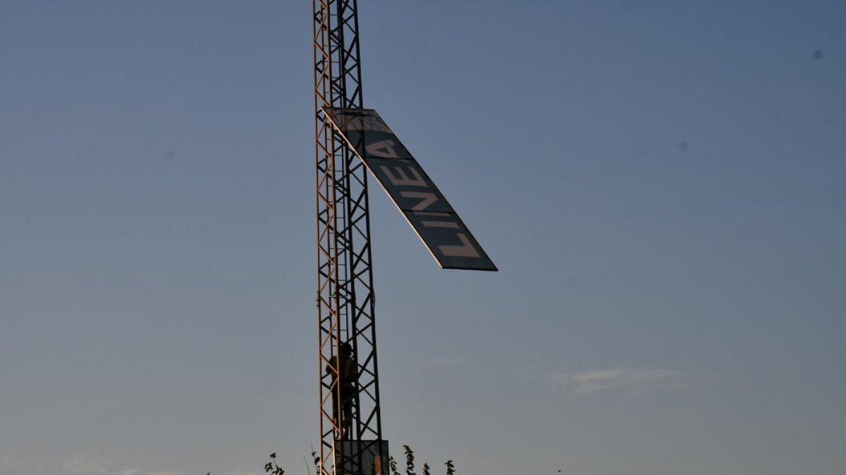 Dos bombers, durant els treballs per despenjar la pancarta publicitària que es va desprendre.