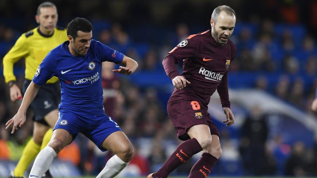 Iniesta controla la pilota davant de Pedro, excompany seu al Barcelona.