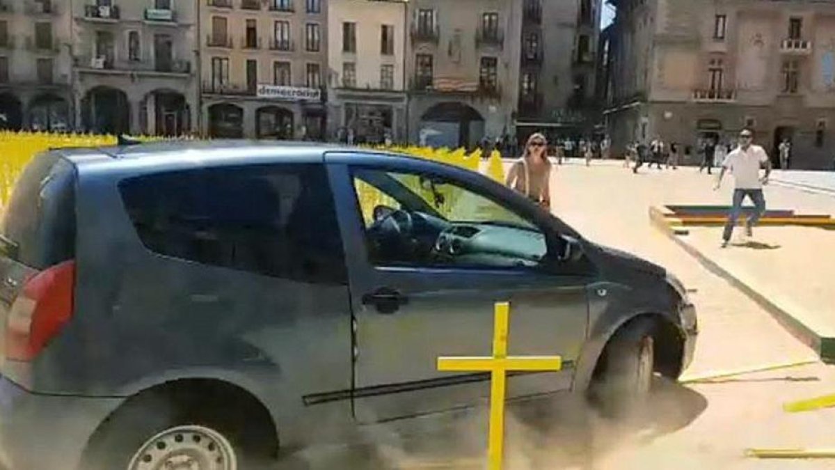 Imagen del coche arrollando varias cruces amarillas.