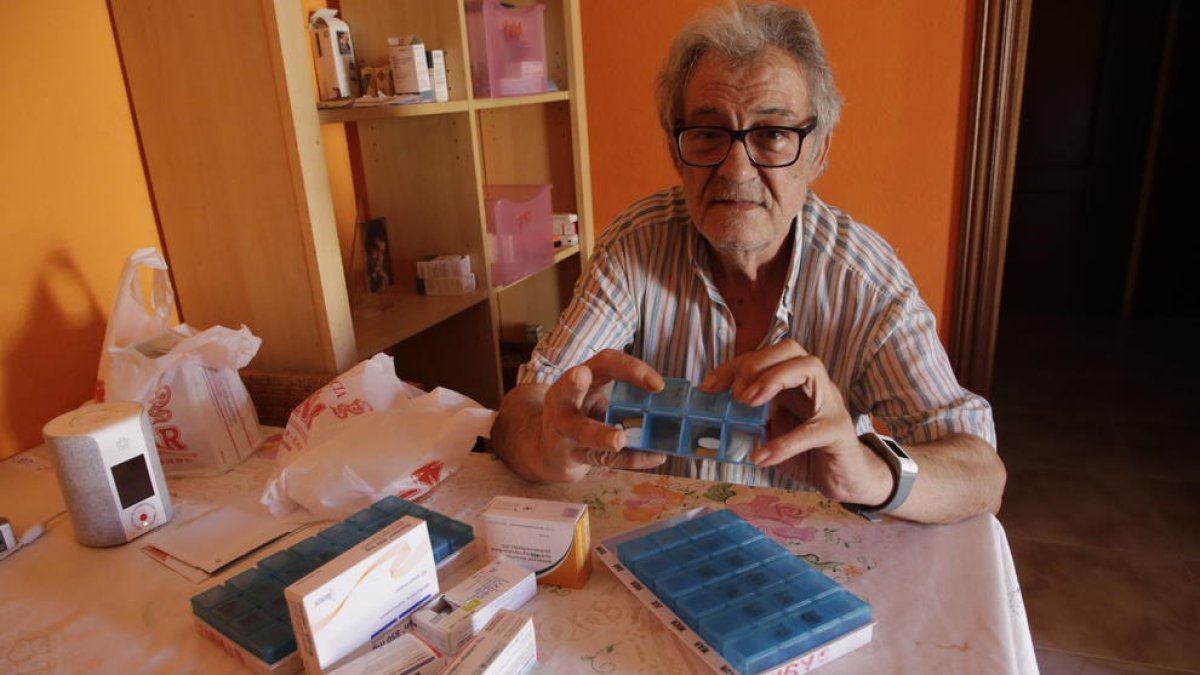Aurelio con los medicamentos que toma cada día y junto a los de su mujer.