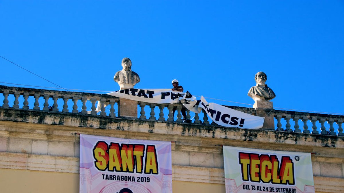 Un operario retiró ayer la pancarta por los presos del ayuntamiento de Tarragona por orden de la JEC.