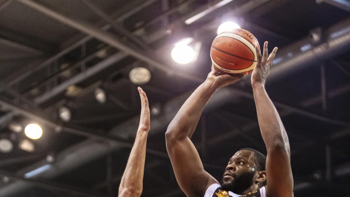 Shaquille llança a cistella davant de l’oposició d’un rival.