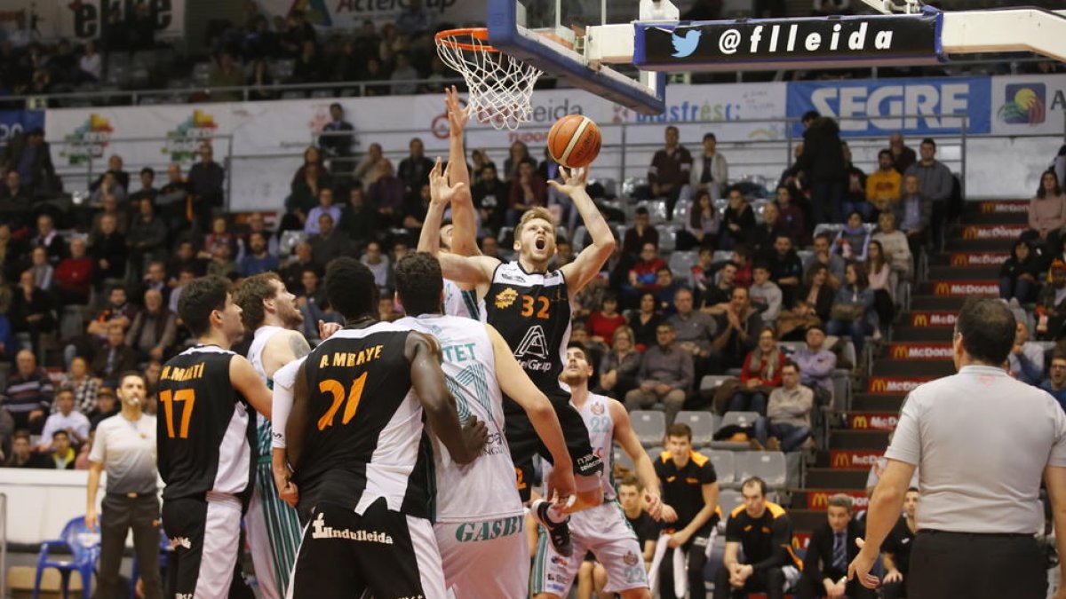 Tim Derksen, perjudicat pels col·legiats, llança a cistella.