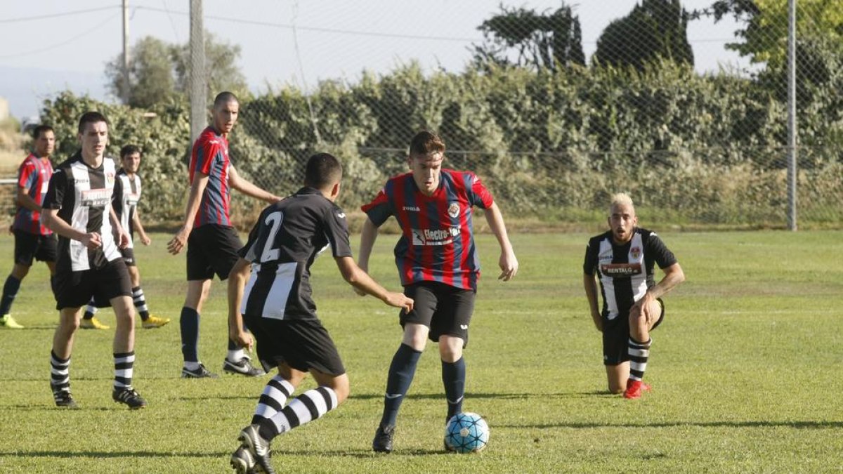 Un jugador del Tàrrega controla el balón ante un futbolista rival.
