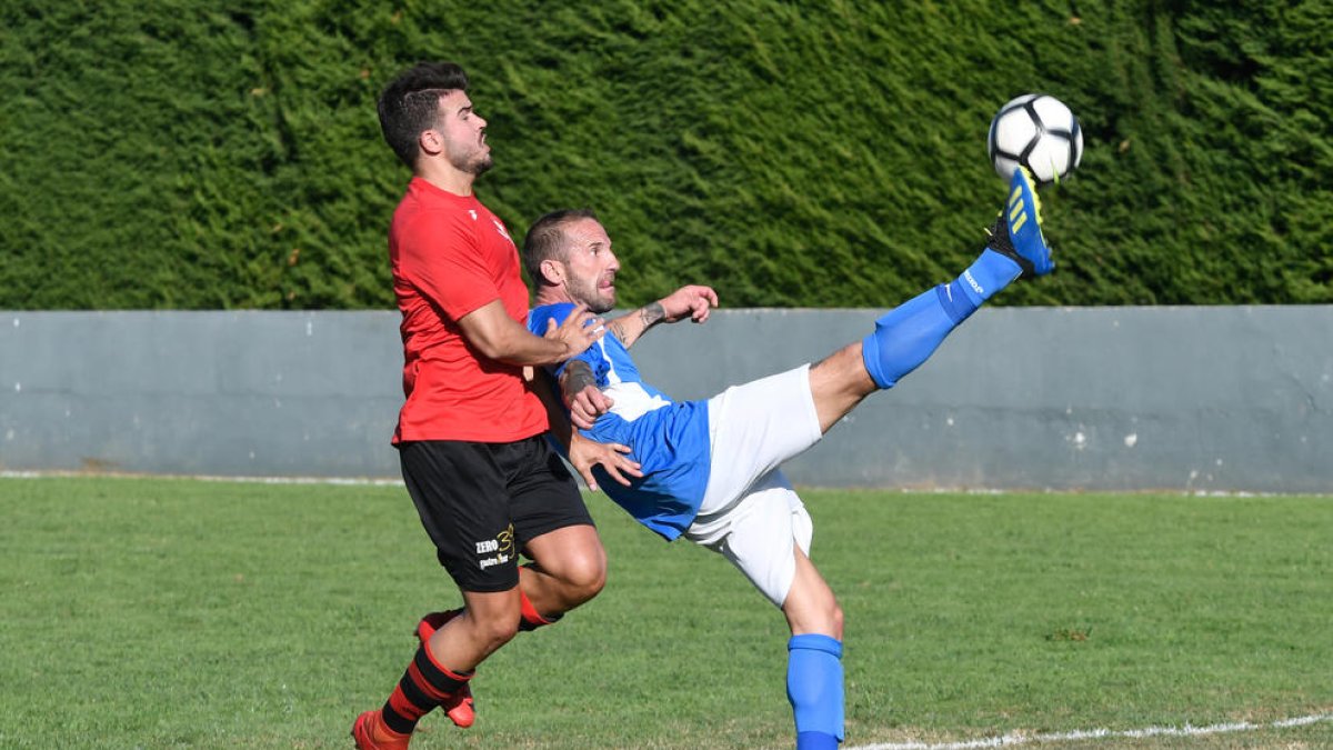 Un jugador de l’EFAC disputa la pilota amb un jugador rival en un moment del partit.
