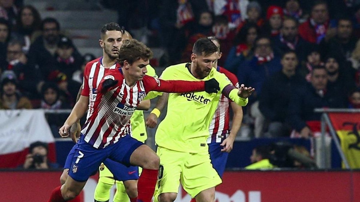 Leo Messi intenta avanzar con el balón ante la presión del francés Griezmann, en un partido en el que ninguno de los dos brilló especialmente.