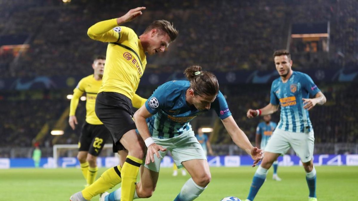 Lukasz Piszczek disputa el balón con el atlético Filipe Luis.