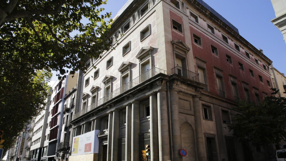 Vista del exterior de la antigua Audiencia, con el cartel que anuncia las obras del Museu d’Art de Lleida junto a la entrada principal.