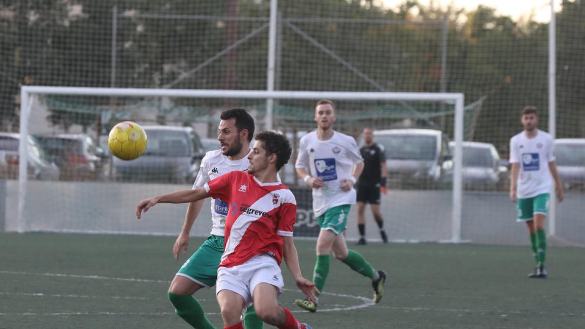 Un jugador de l’Artesa pugna per defensar la possessió de la bimba davant un contrari del Balàfia.