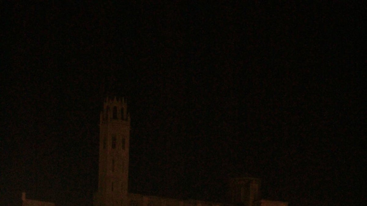 La Seu Vella iluminada, a la izquierda, y a la derecha a oscuras al apagarse las luces.