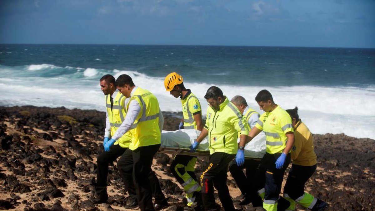 Los servicios de emergencias portando el cuerpo de uno de los fallecidos.