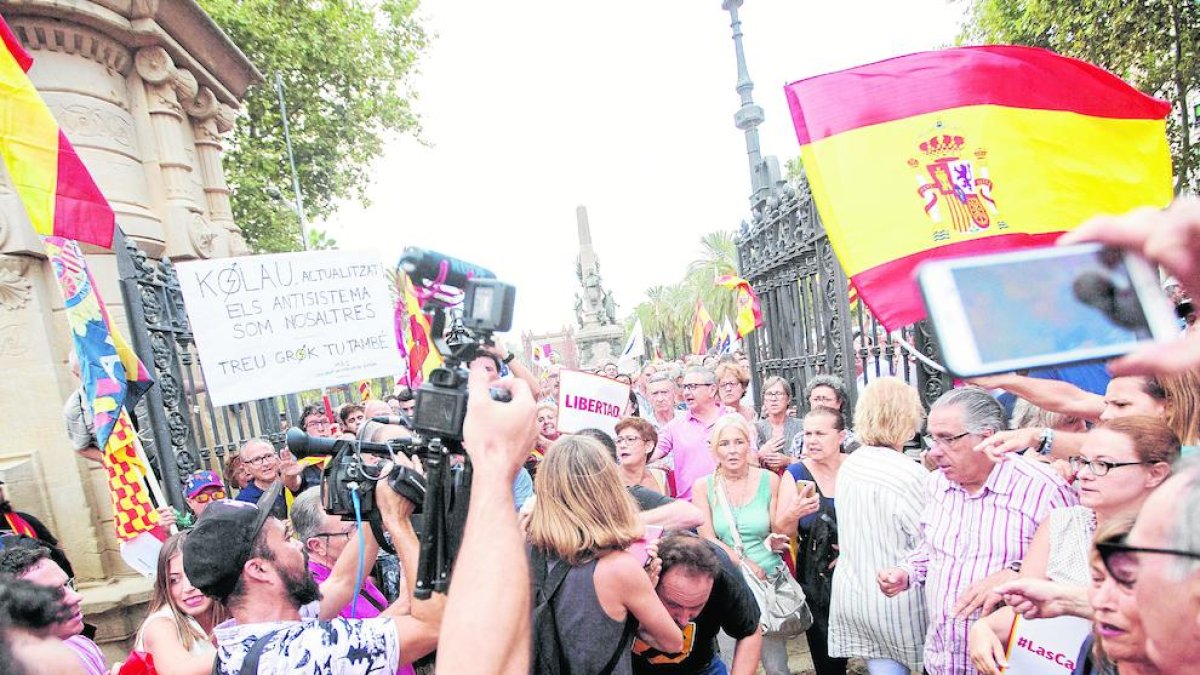 El cámara, agachado en el centro con camiseta negra, tras ser agredido ayer en la Ciutadella.