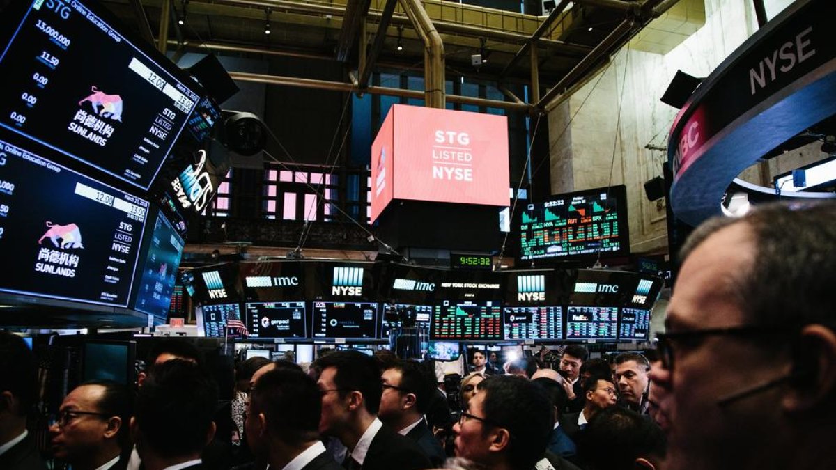 Agentes de bolsa trabajan en el parquet de la Bolsa de Nueva York durante la apertura del viernes.