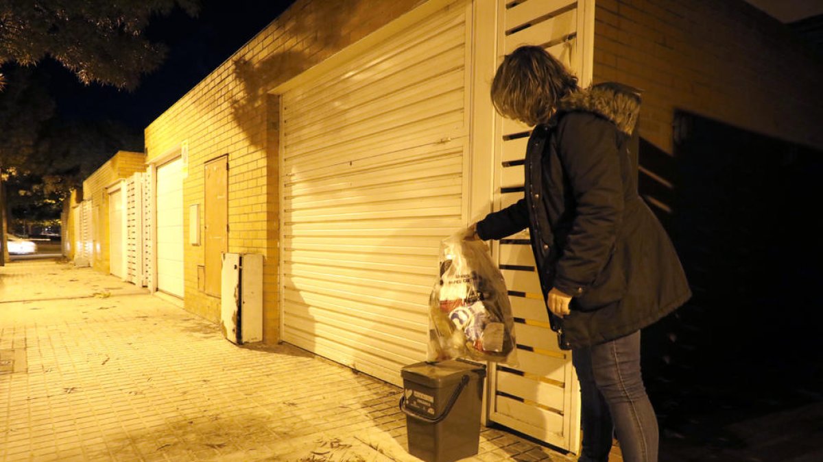 Una vecina de Ciutat Jardí, sacando una bolsa de basura el pasado viernes.