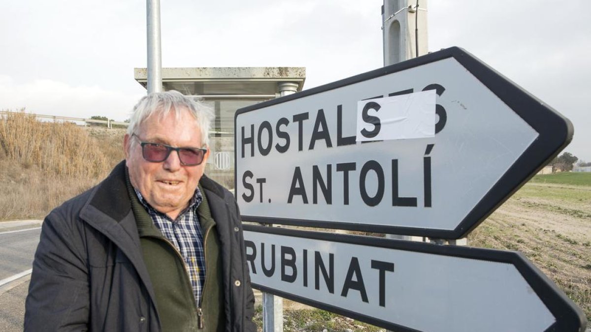 Ramon Tous, que insta l’ajuntament a canviar el nom d’‘Hostalets’ per ‘els Hostals’, davant d’un senyal ‘corregit’ amb un adhesiu.