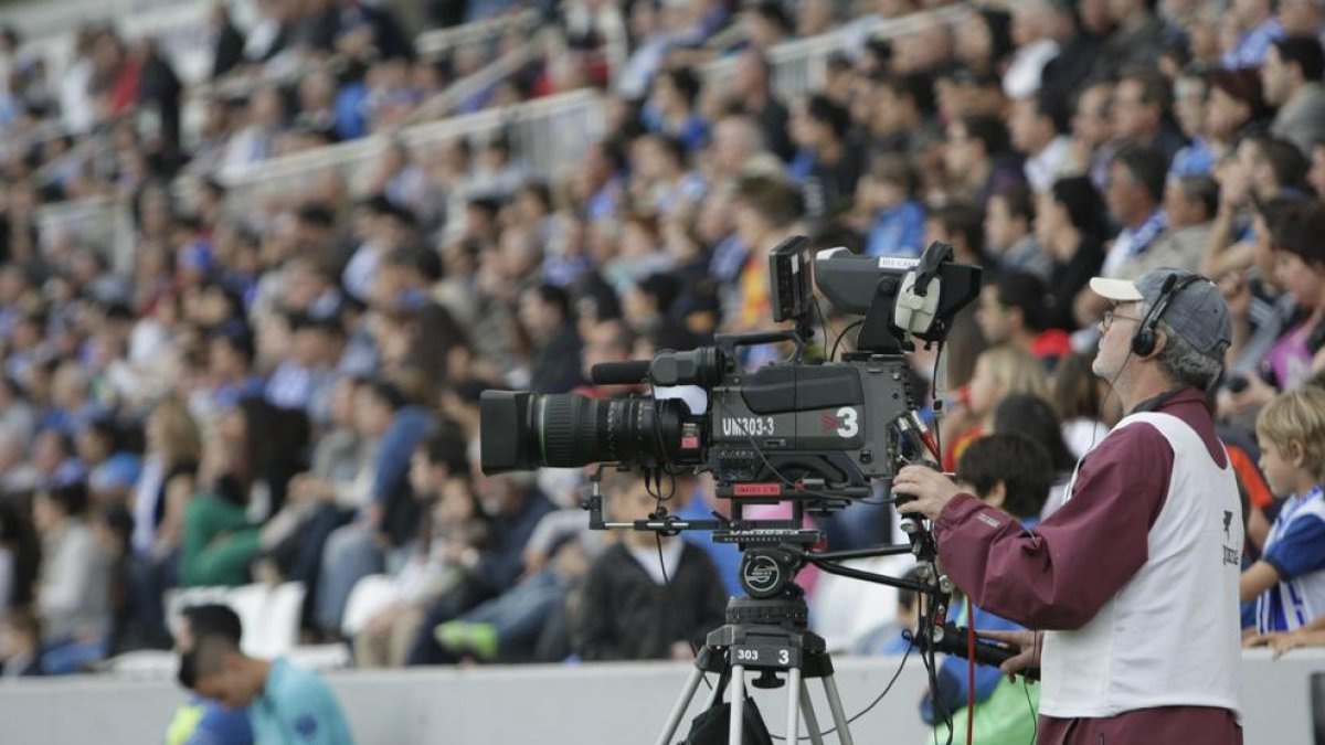 Un tècnic de TV3, amb la càmera durant una retransmissió d’un partit al Camp d’Esports.