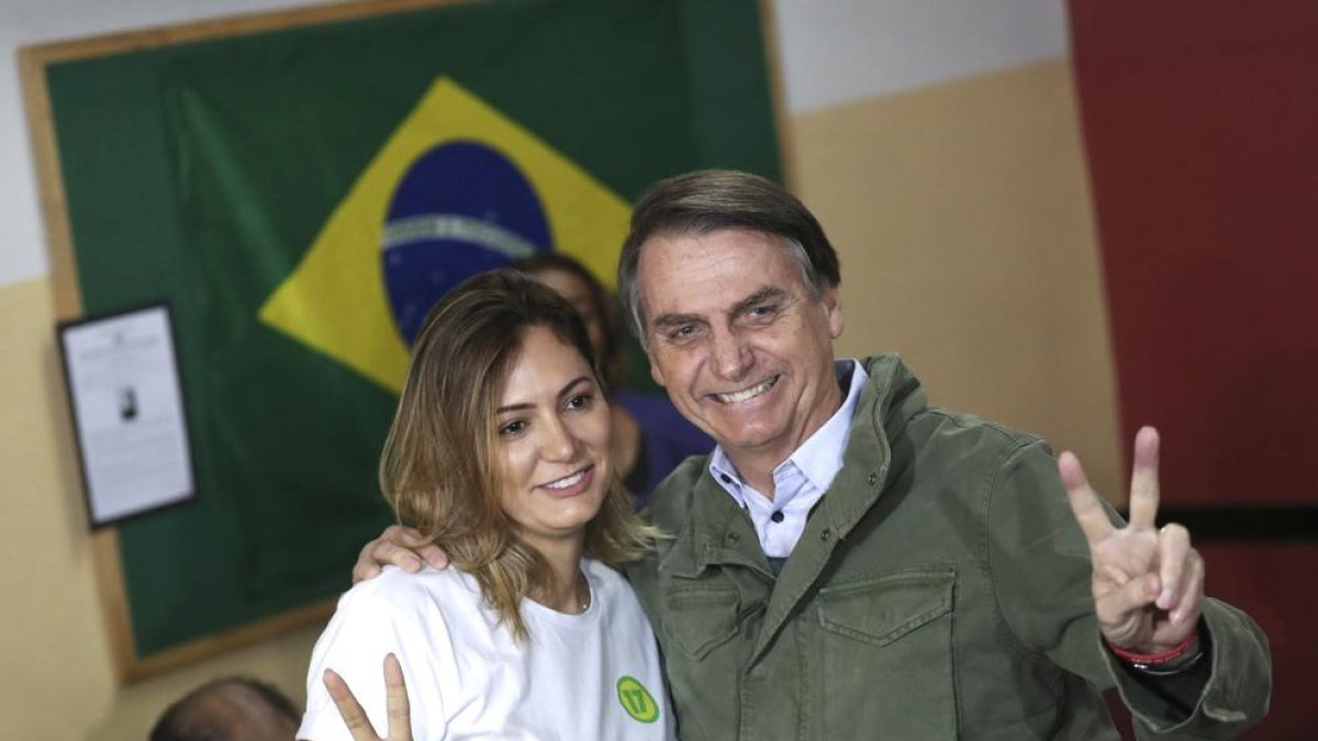 El candidato ultraderechista, Jair Bolsonaro, y su esposa, Michelle, ayer, después de votar.