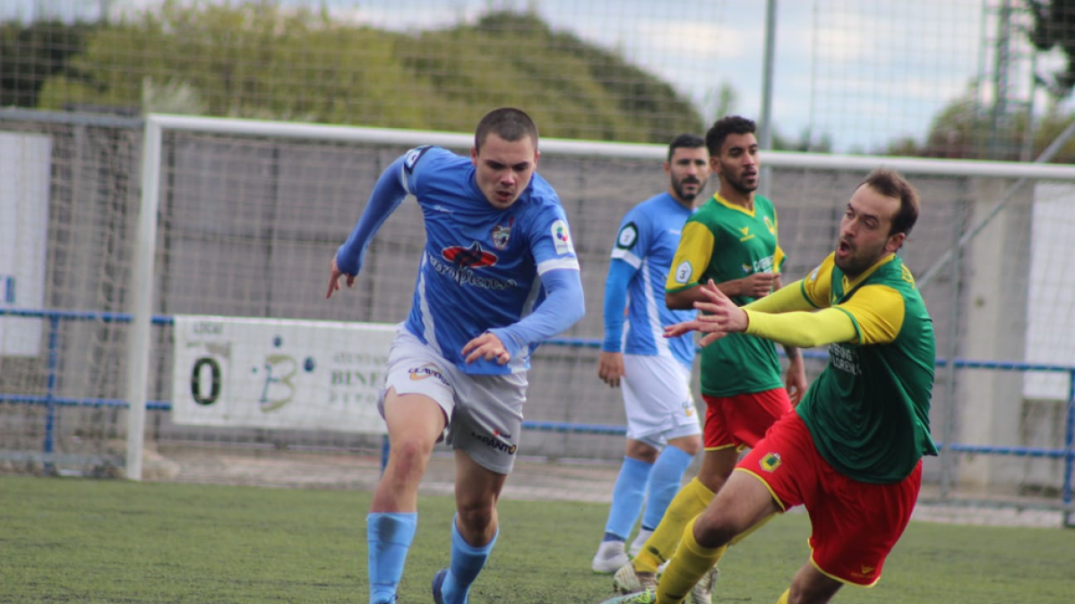 Un jugador del Binéfar supera a un rival en una acción del partido.