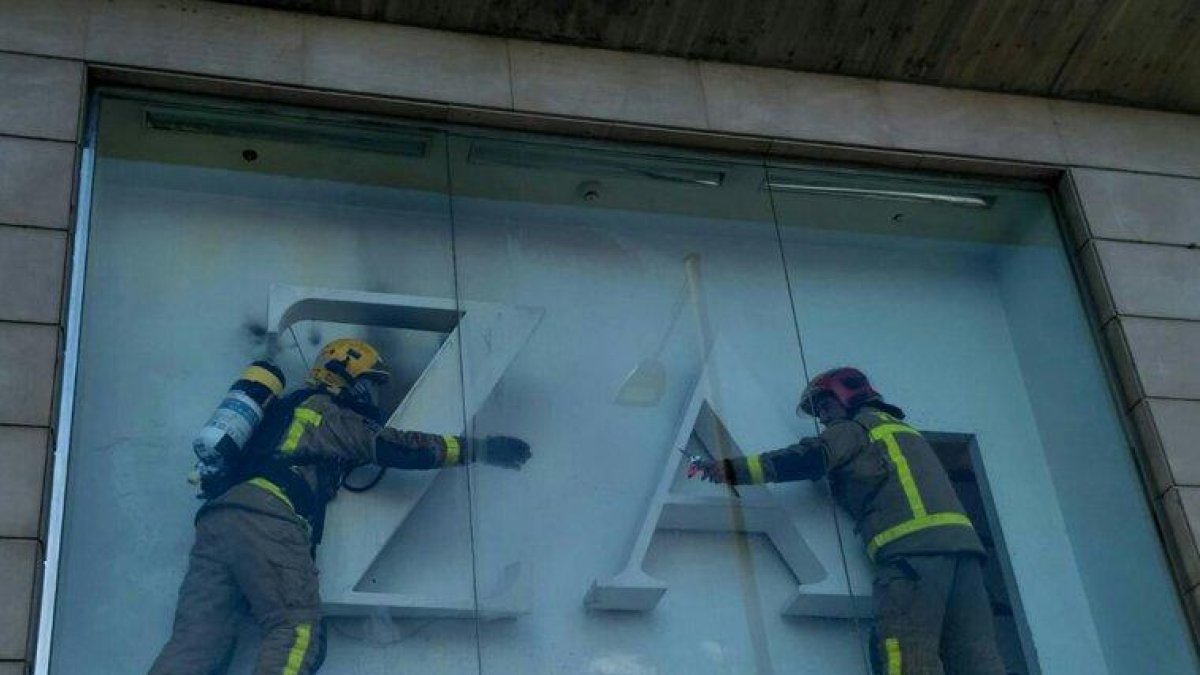 Los Bomberos en el escaparate donde hubo el fuego.
