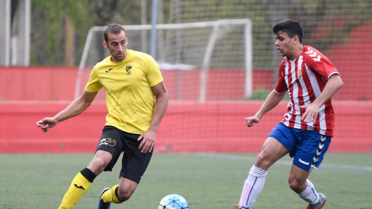 Un jugador de l’EFAC pugna amb un adversari pel control d’una pilota dividida.