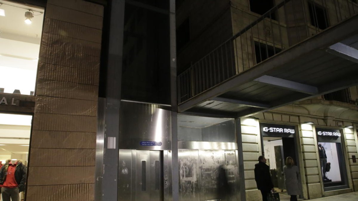 Dos personas pasan por delante del ascensor de la plaza Sant Joan, ayer por la tarde.