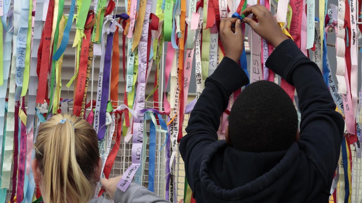 Alcarràs  -  La comunidad educativa de la Escola Parc del Saladar interpretó canciones y colgó unas cintas de colores en la valla con deseos de paz hechos por los niños y niñas de la escuela.