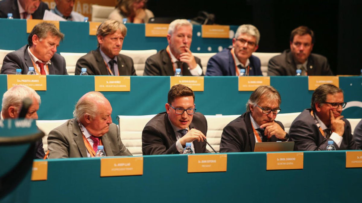 Oriol Camacho, entre el president de l’FCF, Joan Soteras, i el vicepresident, Jordi Terés, es disposa a intervenir en una assemblea.