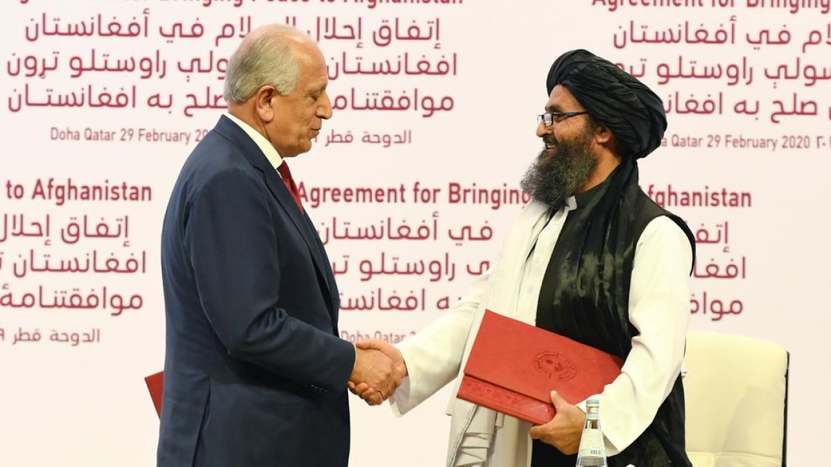 Zalmay Khalilzad, enviat dels EUA, i el mul·là Abdul Ghani Baradar es donen la mà.